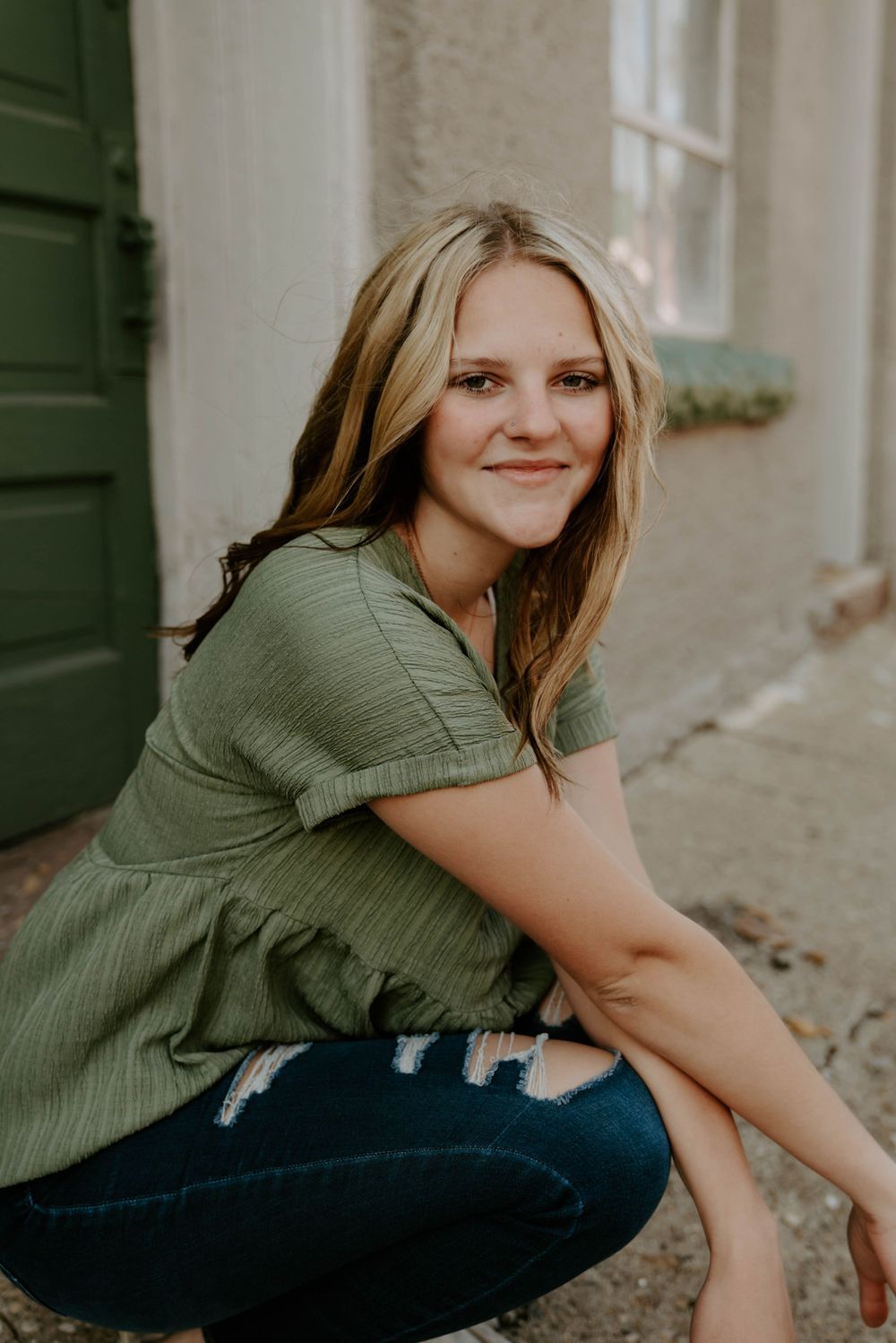 Artistic portrait series showing casual poses in olive green top and distressed denim.