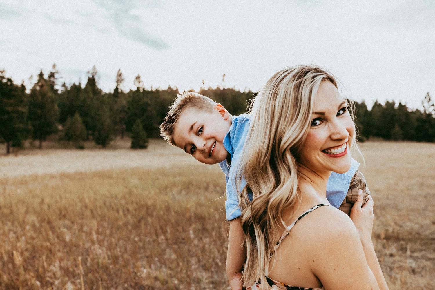 Vanessa Phillips Photo - Billings, MT Photographer -A mother with her son over her shoulder smiling.