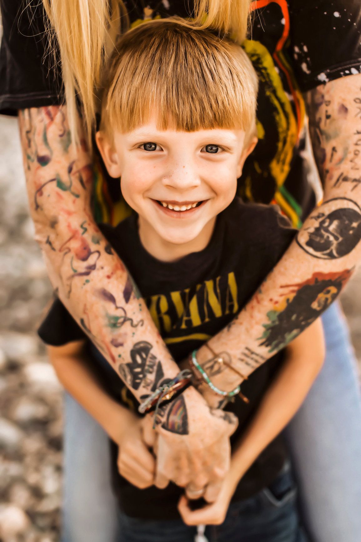Vanessa Phillips Photo - Billings, MT Photographer - a boy smiling at the camera with his mom's arms around him.