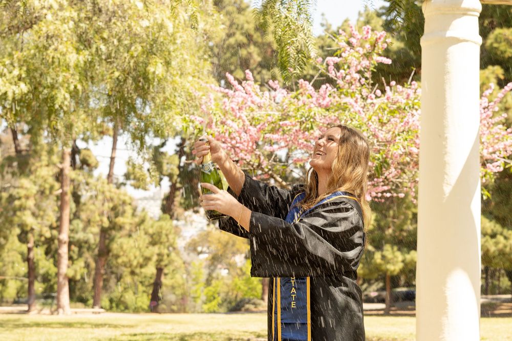 San Diego senior portrait with cap and gown under the trees at Presidio Park