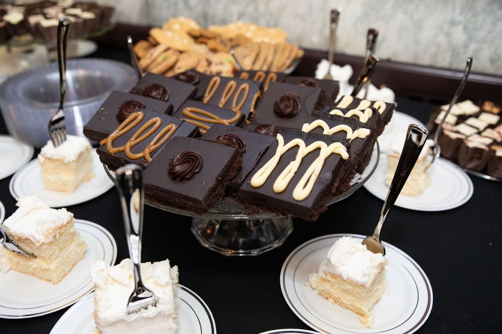 An assortment of chocolate and vanilla desserts displayed on white plates at a wedding reception.