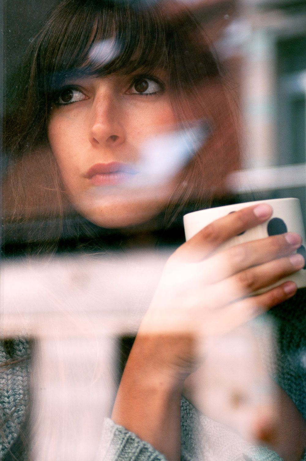 Artistic blurred portrait sequence with motion effect and hands covering face.