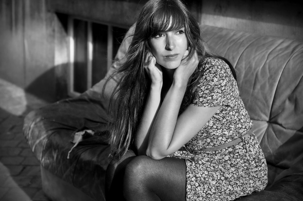 Black and white boudoir portrait with floral dress and dramatic shadows.