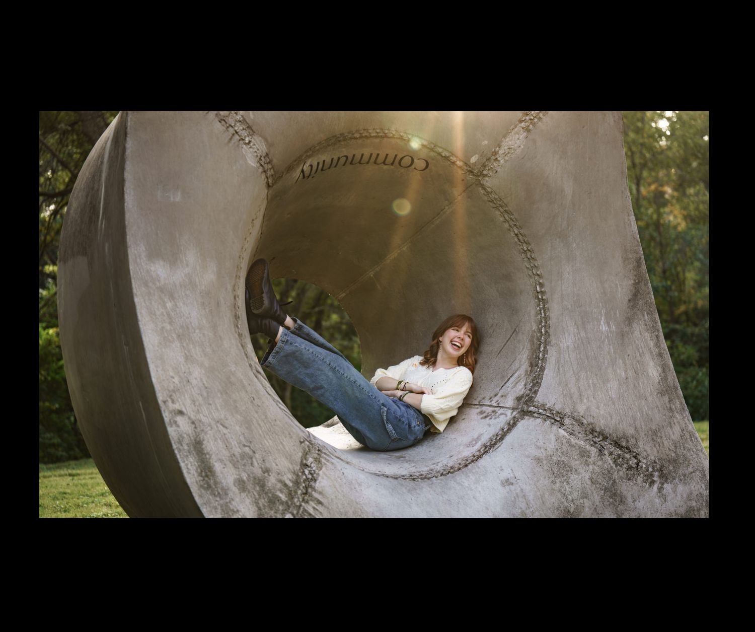 girl laughs while sitting in park