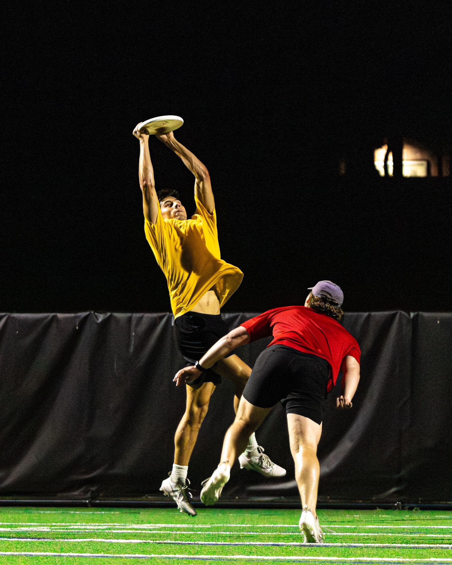 Frisbee player performs a sequence of athletic moves on a turf field against a black background.