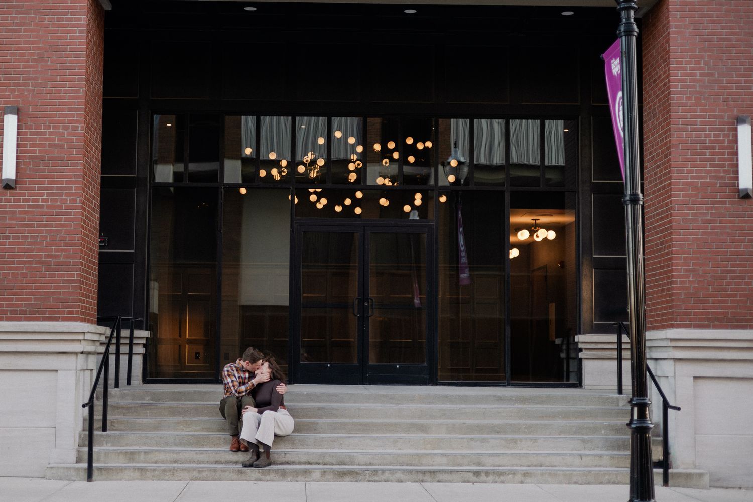 downtown springfield missouri engagement sessions by hotel vandivort, couple sitting and kissing on stairs