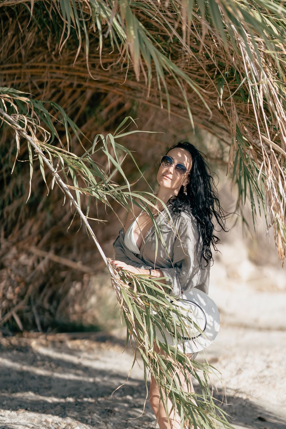 Artistic beauty portrait under palm fronds in natural sunlight.
