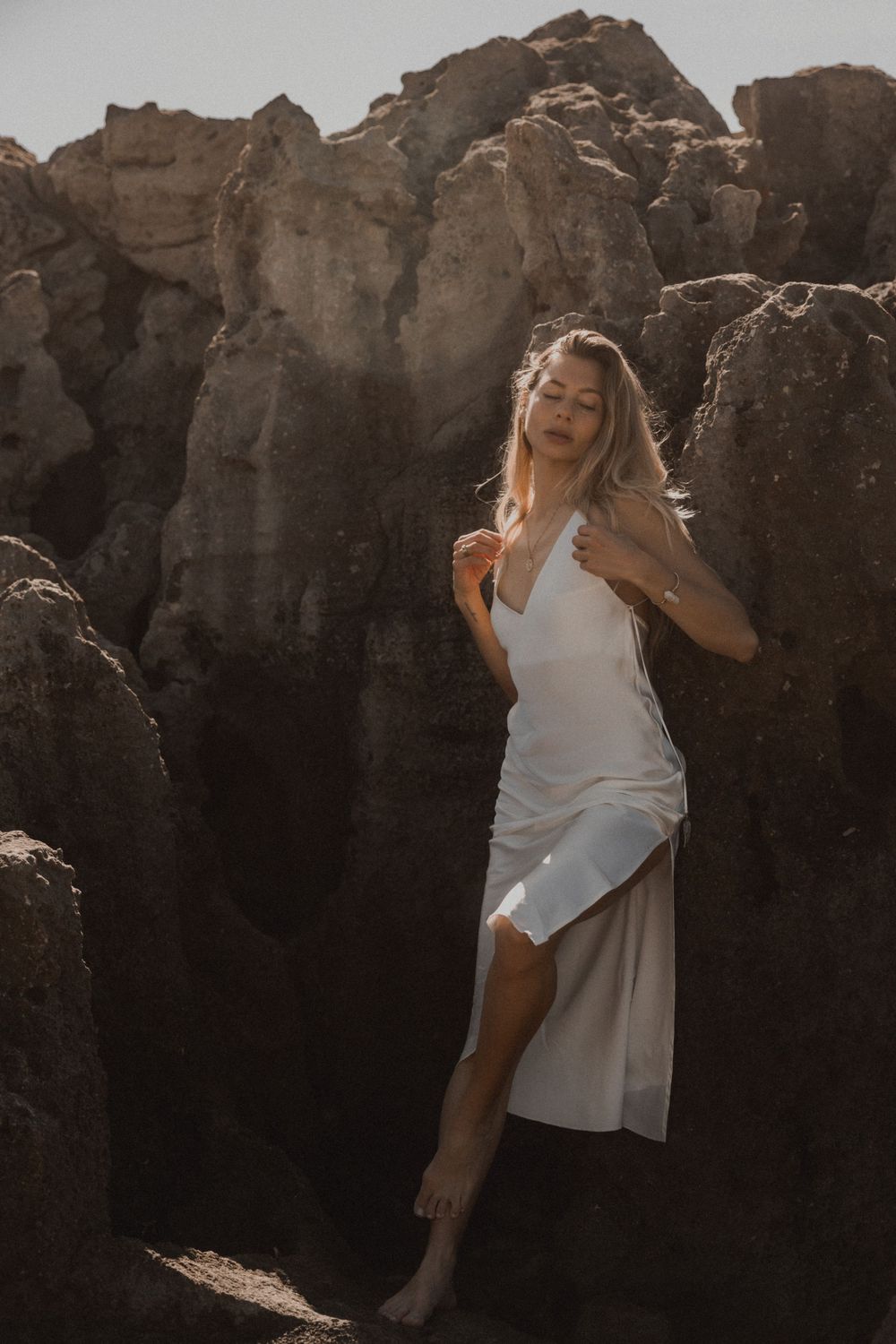 Artistic portrait sequence showing graceful movement against rugged rock formations.