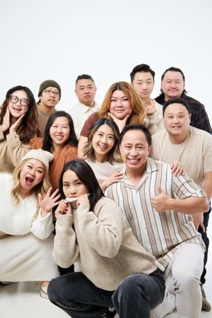 Diverse group of young Asian friends posing together and making playful expressions in a studio setting.