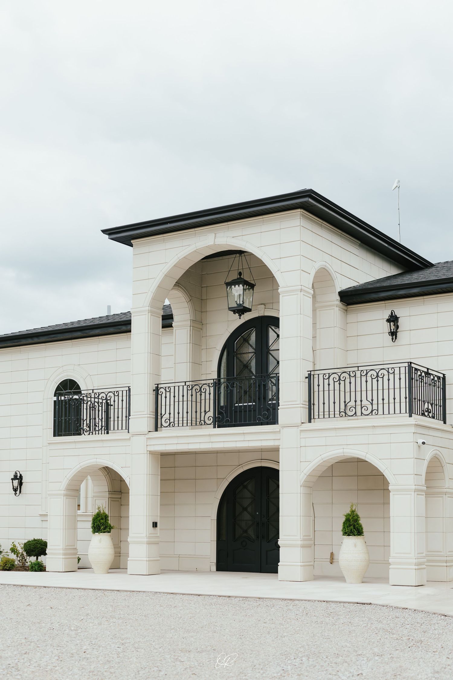 Event venue setup with elegant white archways, 'Black Sands' signage, and formal table settings against dark background.