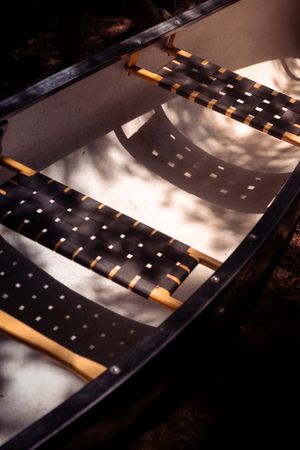 Wooden bench interior casting dramatic shadows through slat design in morning sunlight.