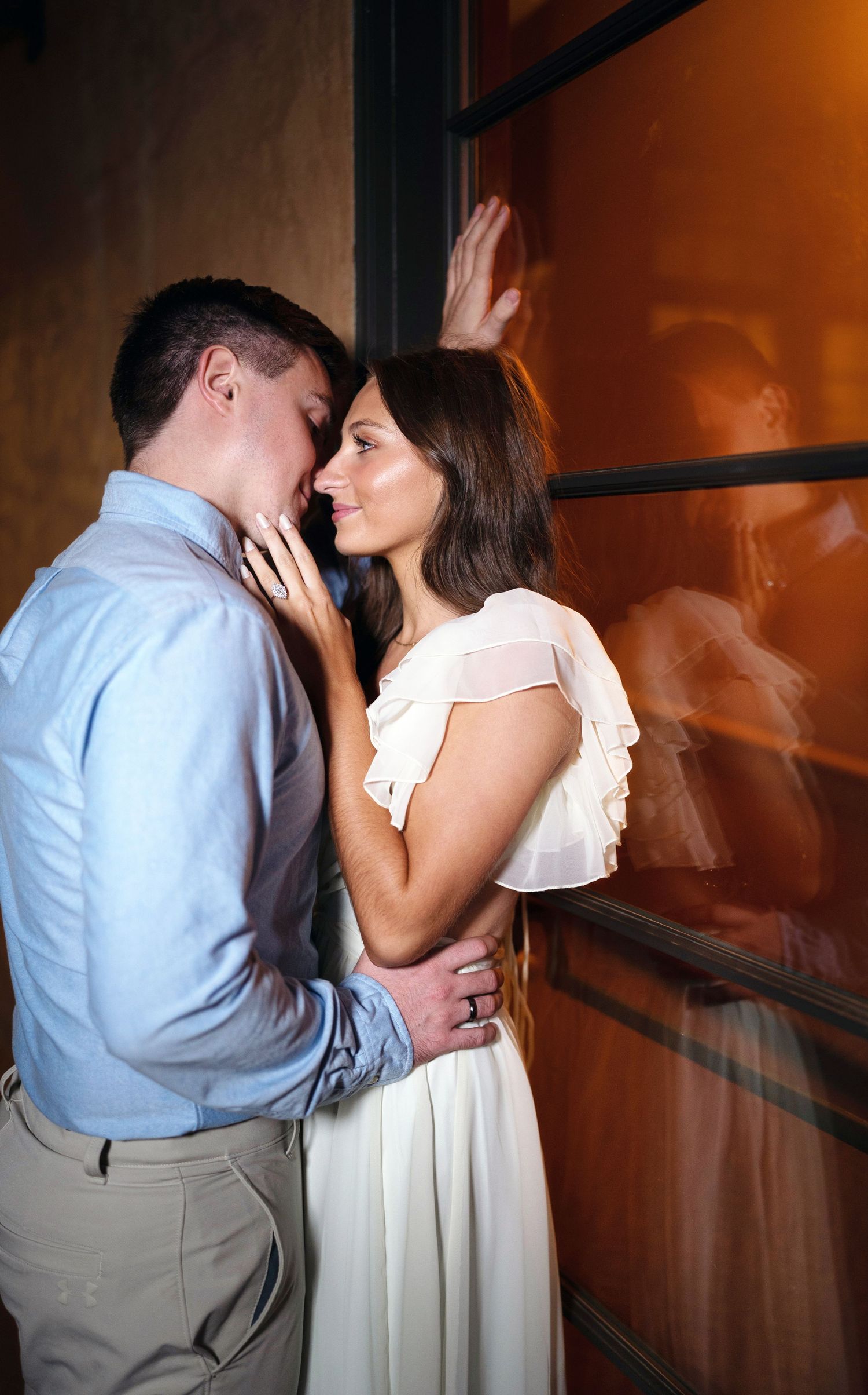 A romantic couple in formal attire share intimate moments against a warm-lit wall in a progressive photo sequence.
