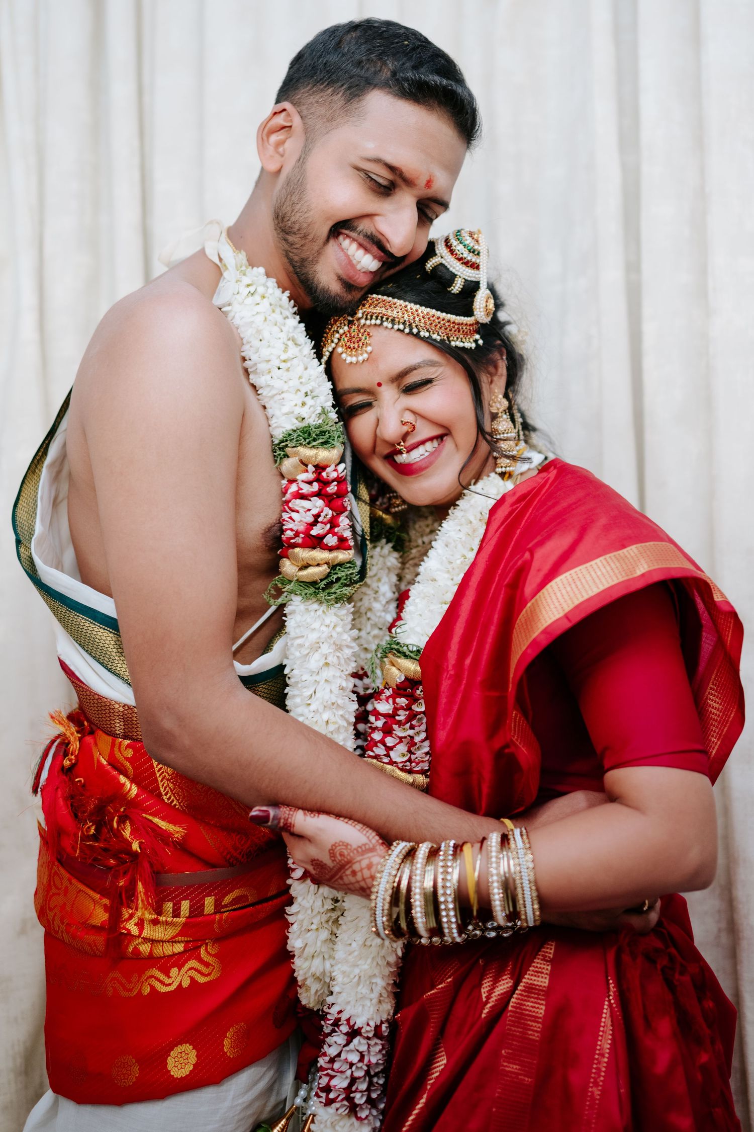 Close-up photos of a couple in traditional Indian wedding attire sharing intimate moments and smiles.