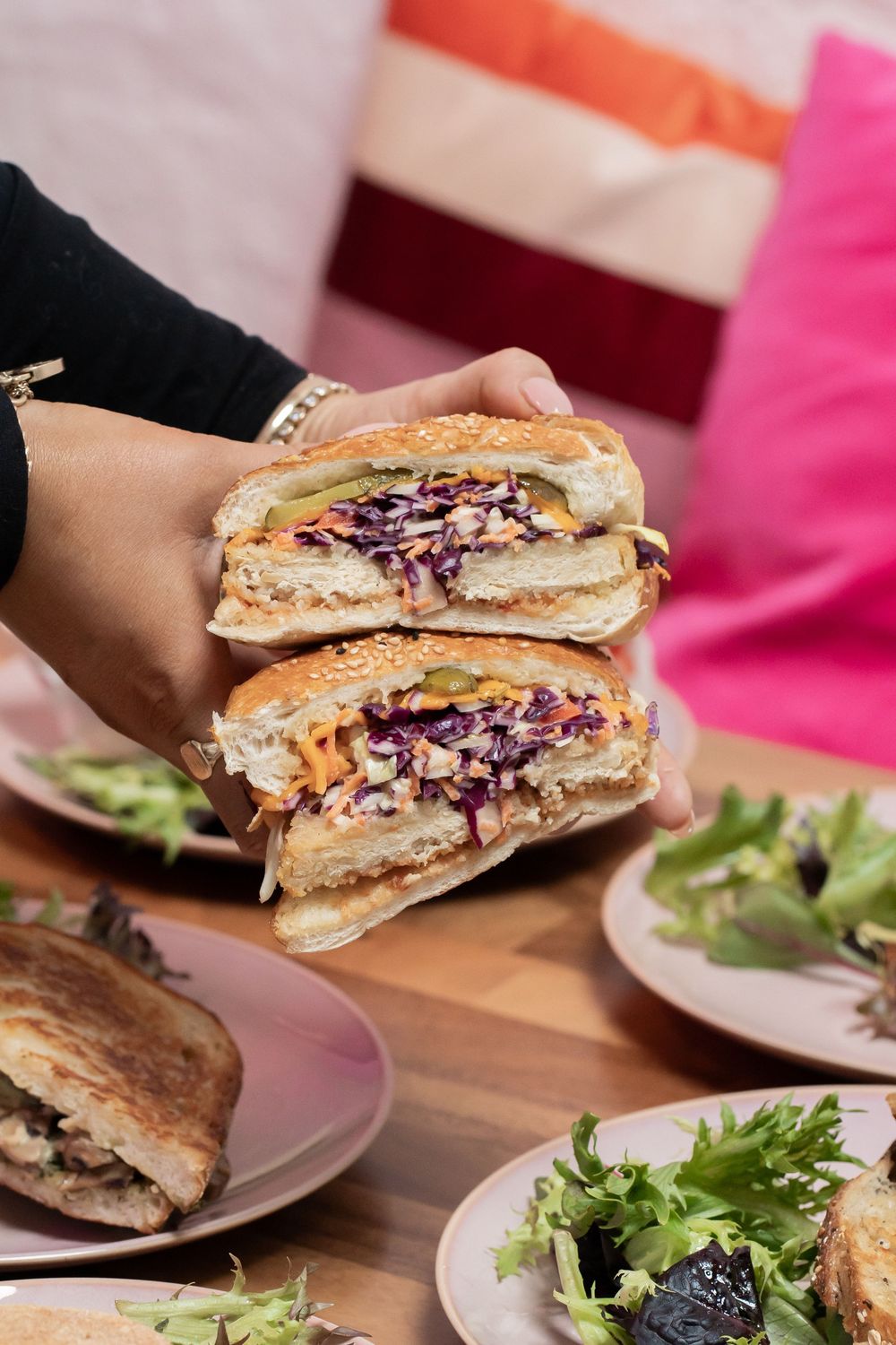 Cross-section views of grilled sandwiches with colorful fillings served with fresh salad.