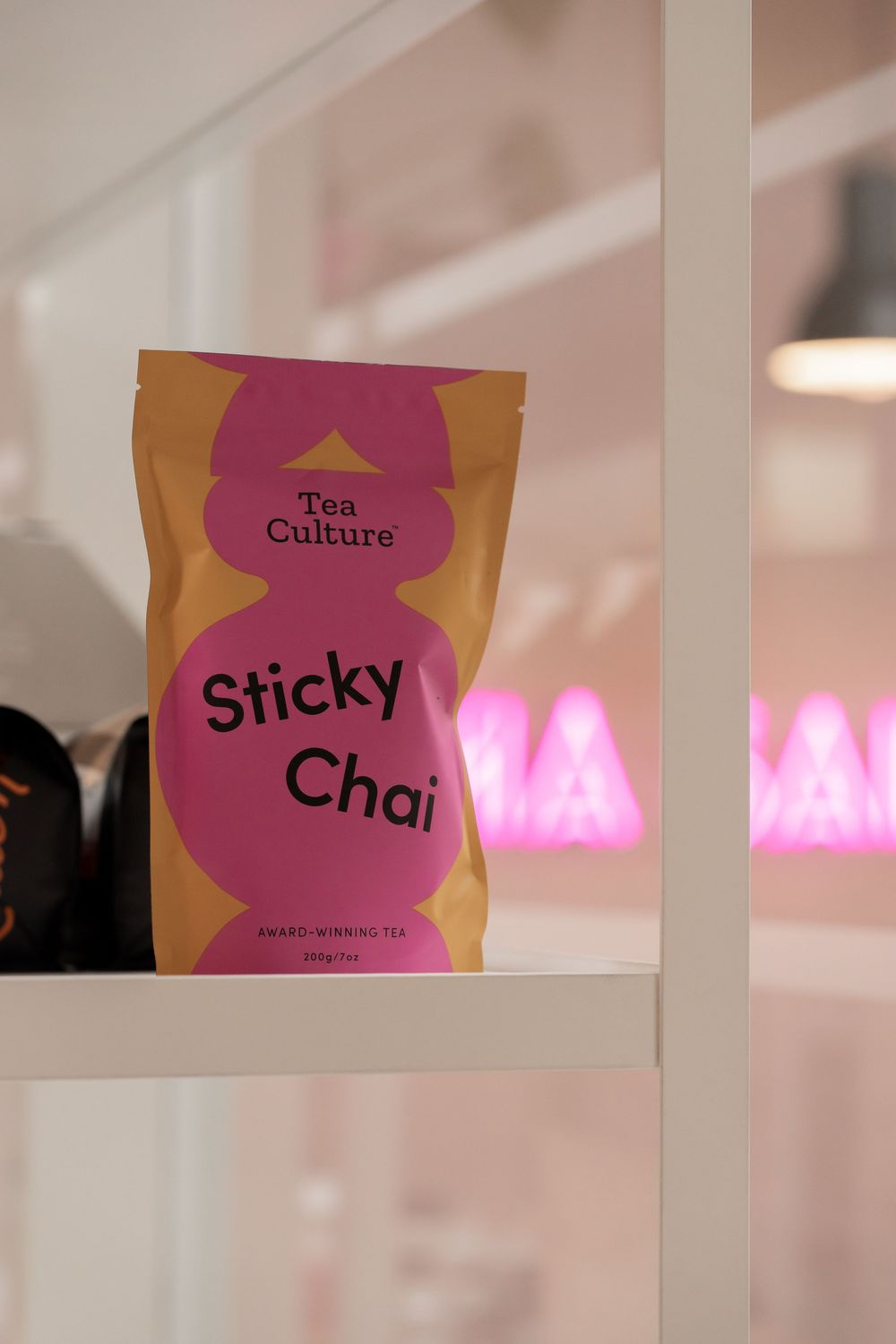 Tea menu signs displaying 'Sticky' and 'Chai' options in pink and orange colors.