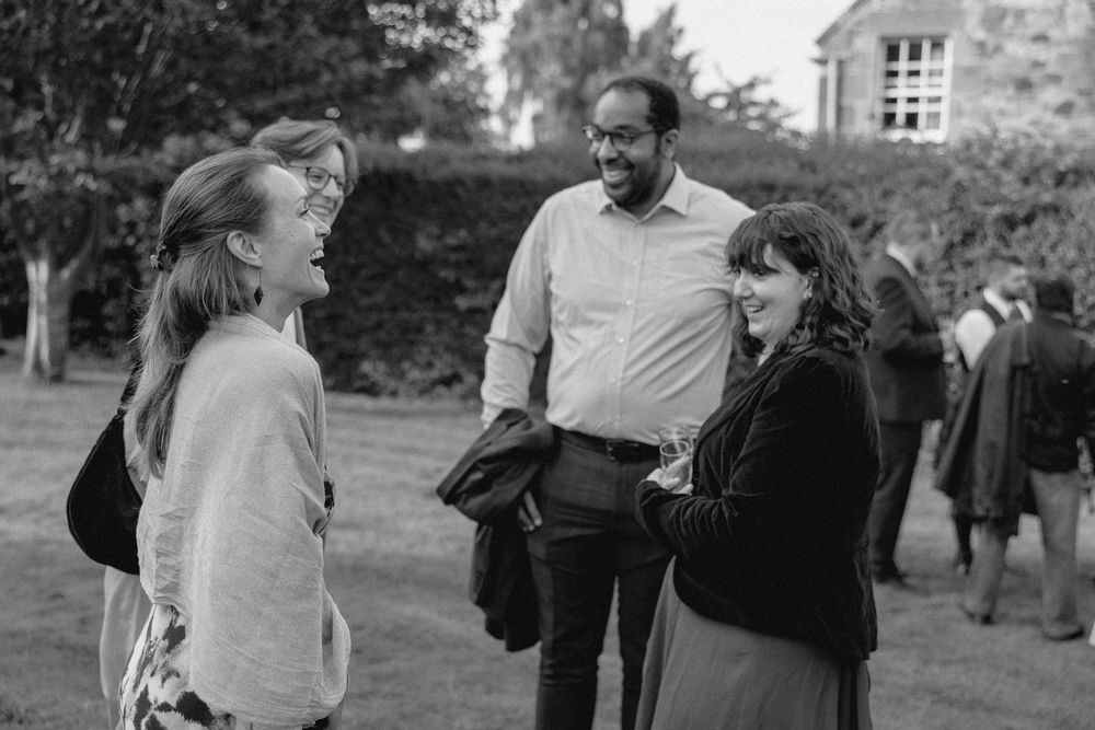 A black and white photo series showing people gathered outdoors near stone buildings in what appears to be the 1950s.