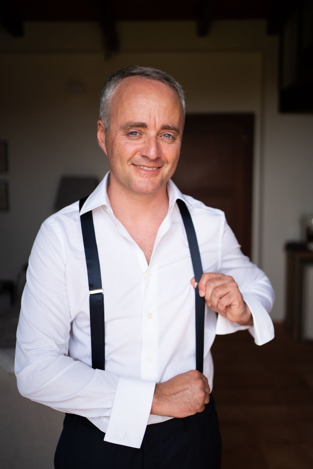 Man in white dress shirt and suspenders making playful expressions in a series of portrait photos.