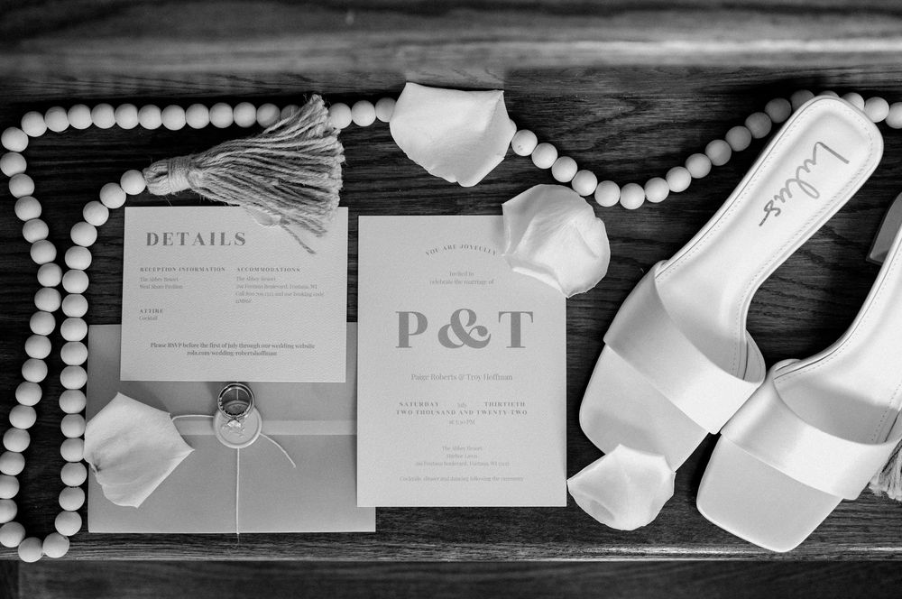 Black and white photo of elegant wedding invitation suite with pearls and decorative details.