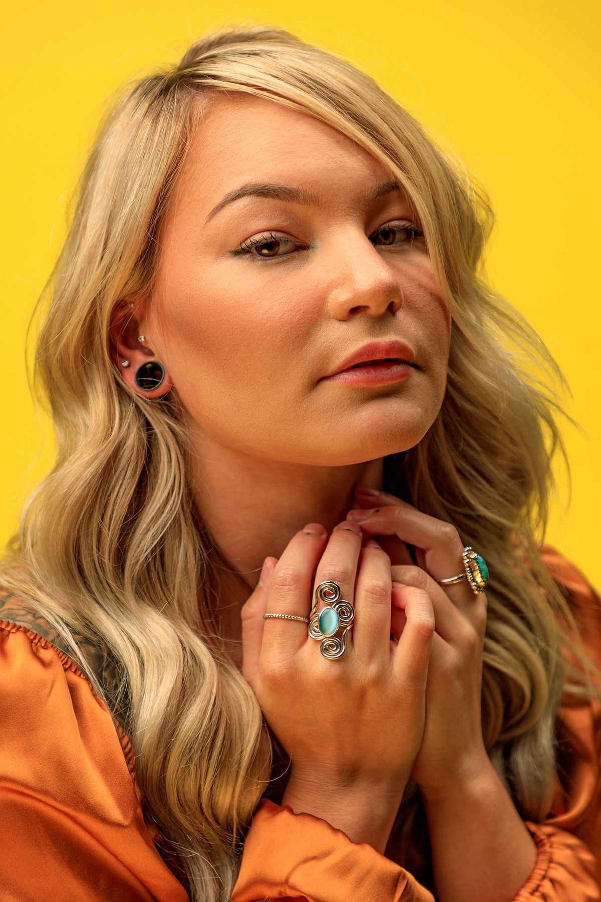 Close-up beauty shots with vibrant yellow background featuring dramatic makeup and jewelry. portrait photography st louis.