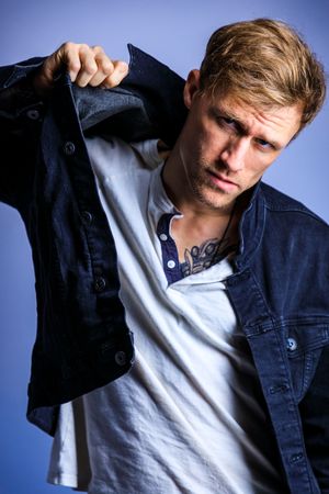 Fashion sequence showing casual denim jacket styling against blue backdrop. portrait photography st louis.