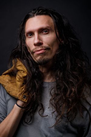 Dramatic portrait series with long dark hair and gray shirt against black background. photography st louis.