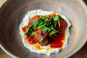 White sauce and meatballs in tomato sauce served in rustic ceramic bowls. live event photography st louis.