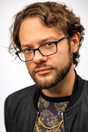 Series of headshots showing person with glasses and beard making various expressions against white background. photography st louis.