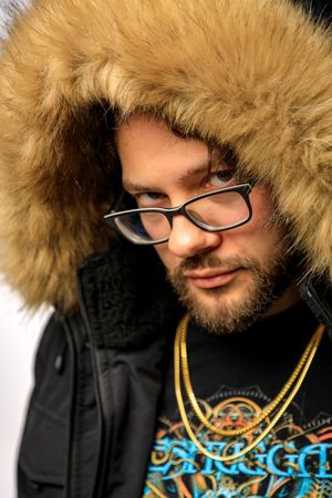 Portrait sequence showing person wearing fur-lined hood and glasses against white studio backdrop. photography st louis.