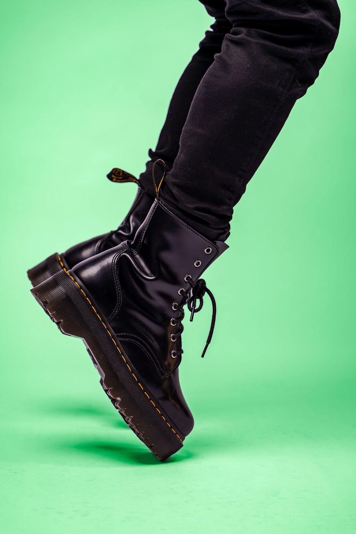 Black combat boots in motion against green background showing dynamic walking sequence. portrait photography st louis.