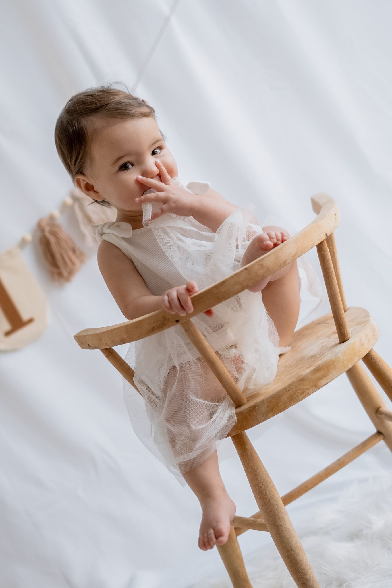 A series of photos showing a small child playing with a wooden rocking chair against a white backdrop. Photography in Buckinghamshire.