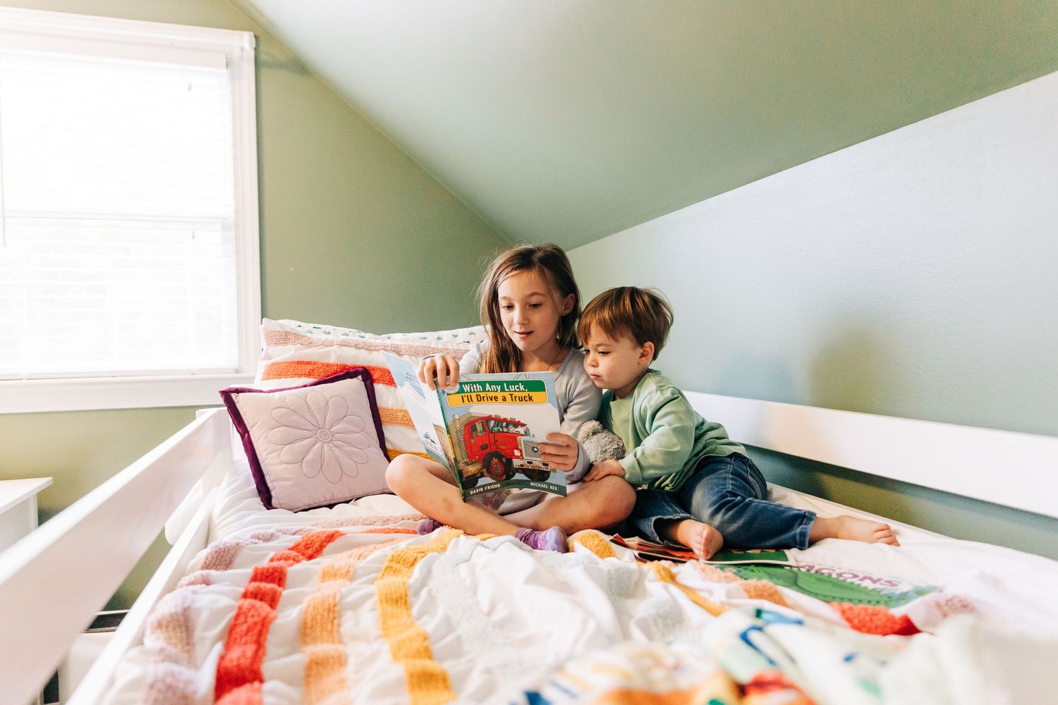 People reading and learning together on a cozy bed surrounded by colorful books and educational materials.