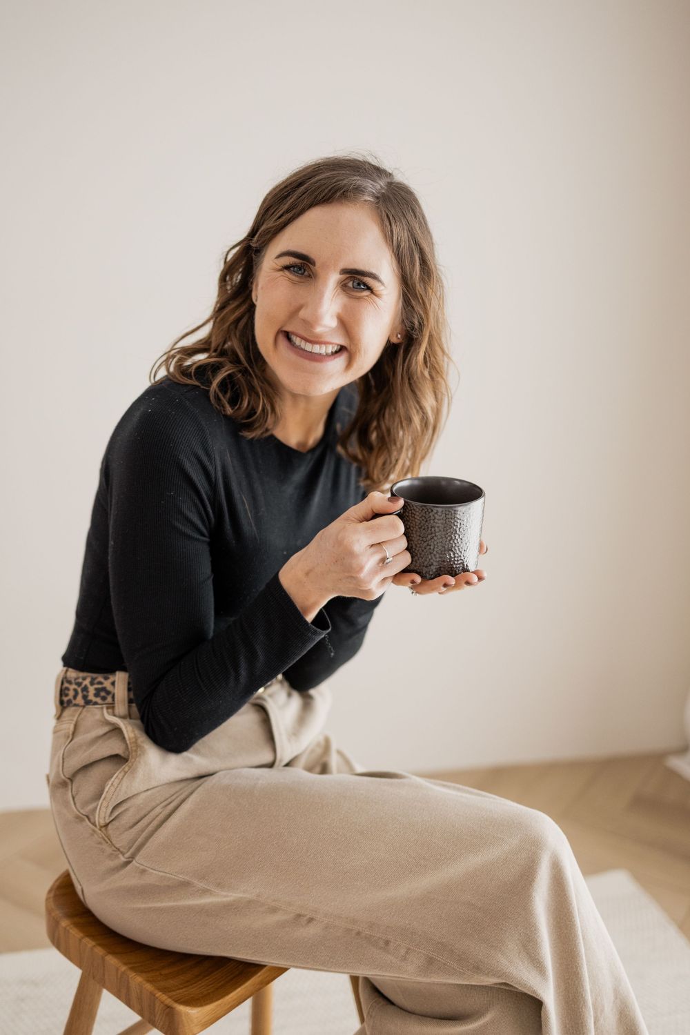 A person wearing a black sweater and beige pants sits casually in a series of lifestyle portraits. Photography in Buckinghamshire.