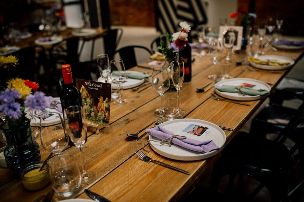 Place settings and glassware arranged on a rustic wooden dining table for an elegant dinner party.