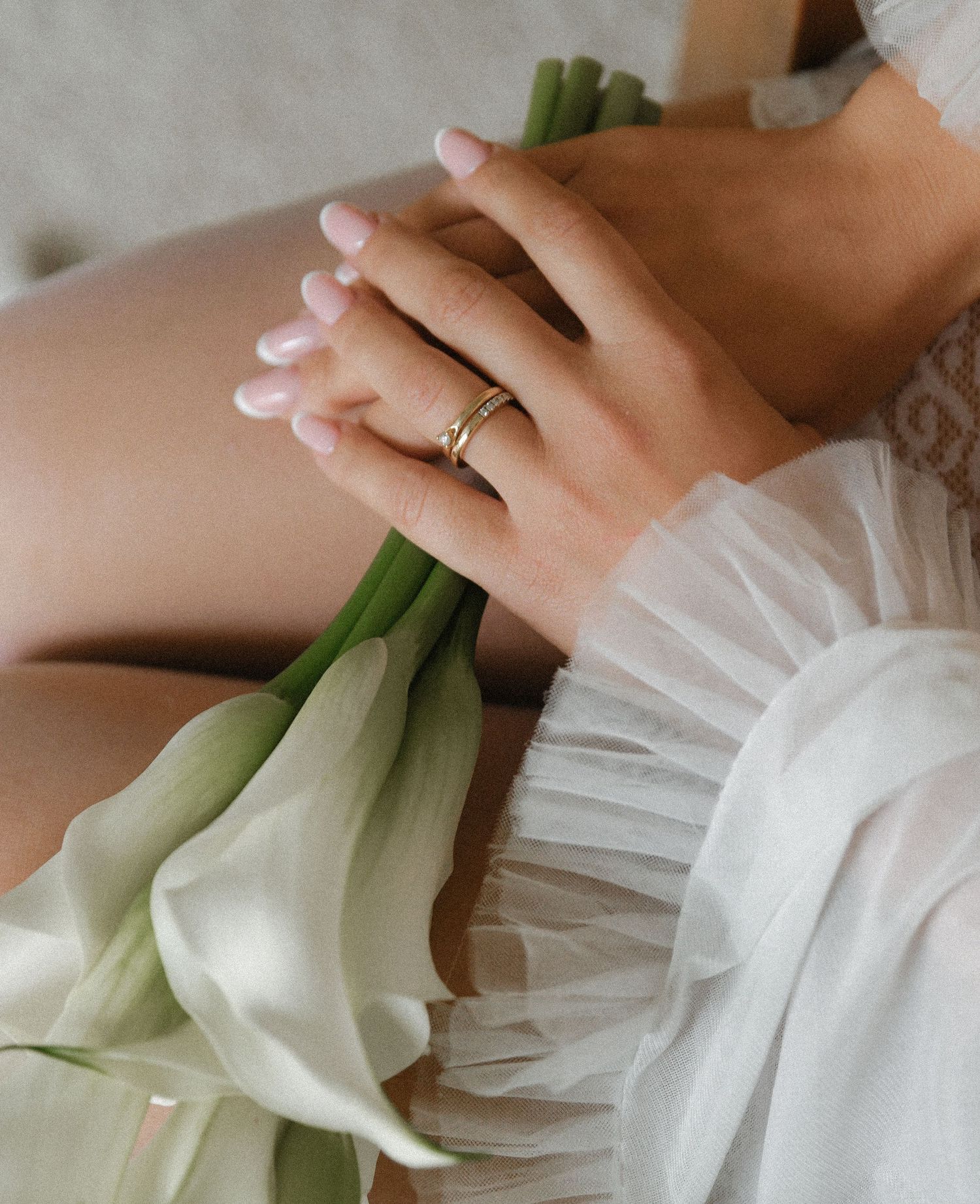 Hands gently wrapping and folding white fabric around a fresh green leek in a step-by-step preparation sequence.