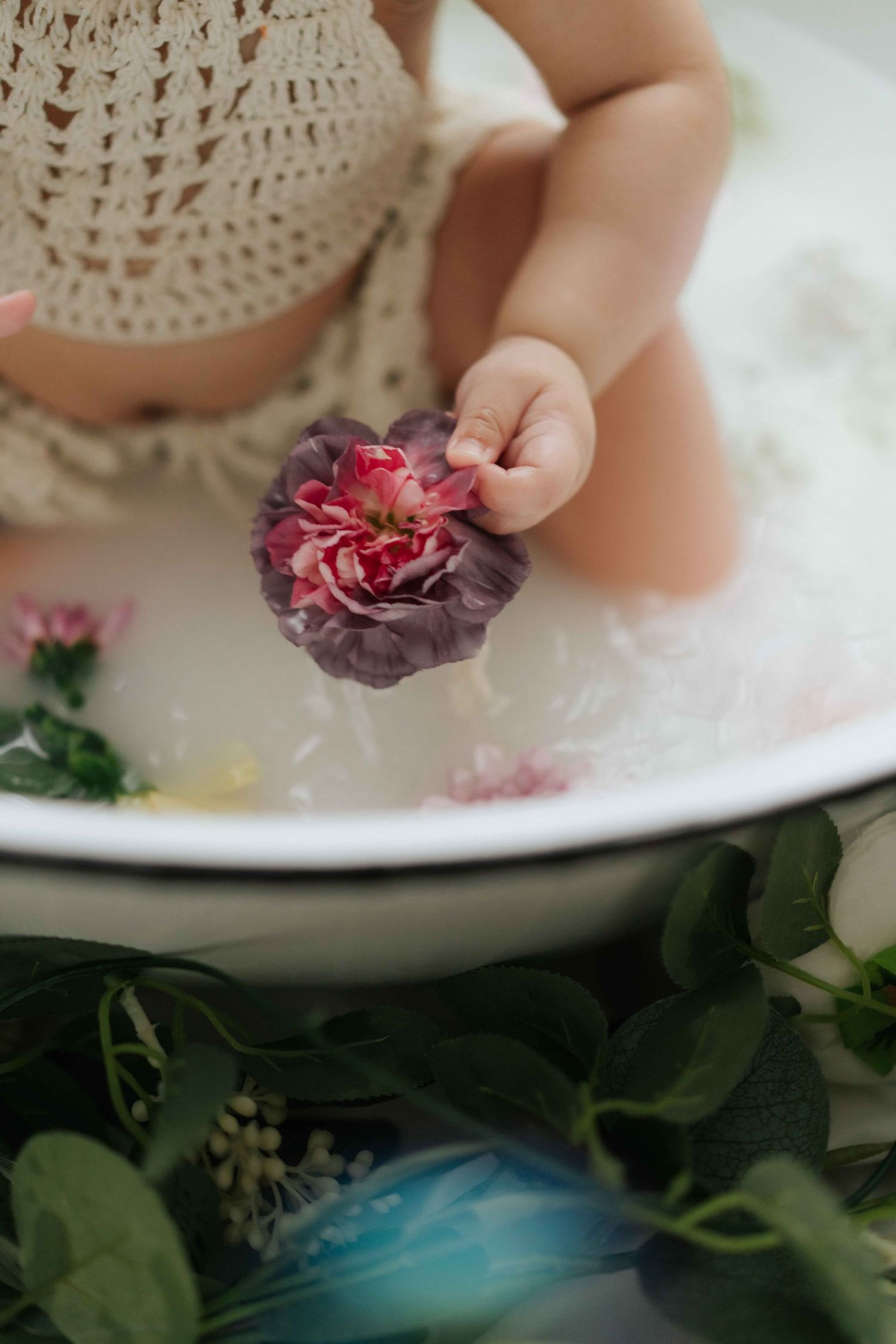 Cake smash photo session setup with white balloons, sunflowers and a baby enjoying their first birthday celebration.