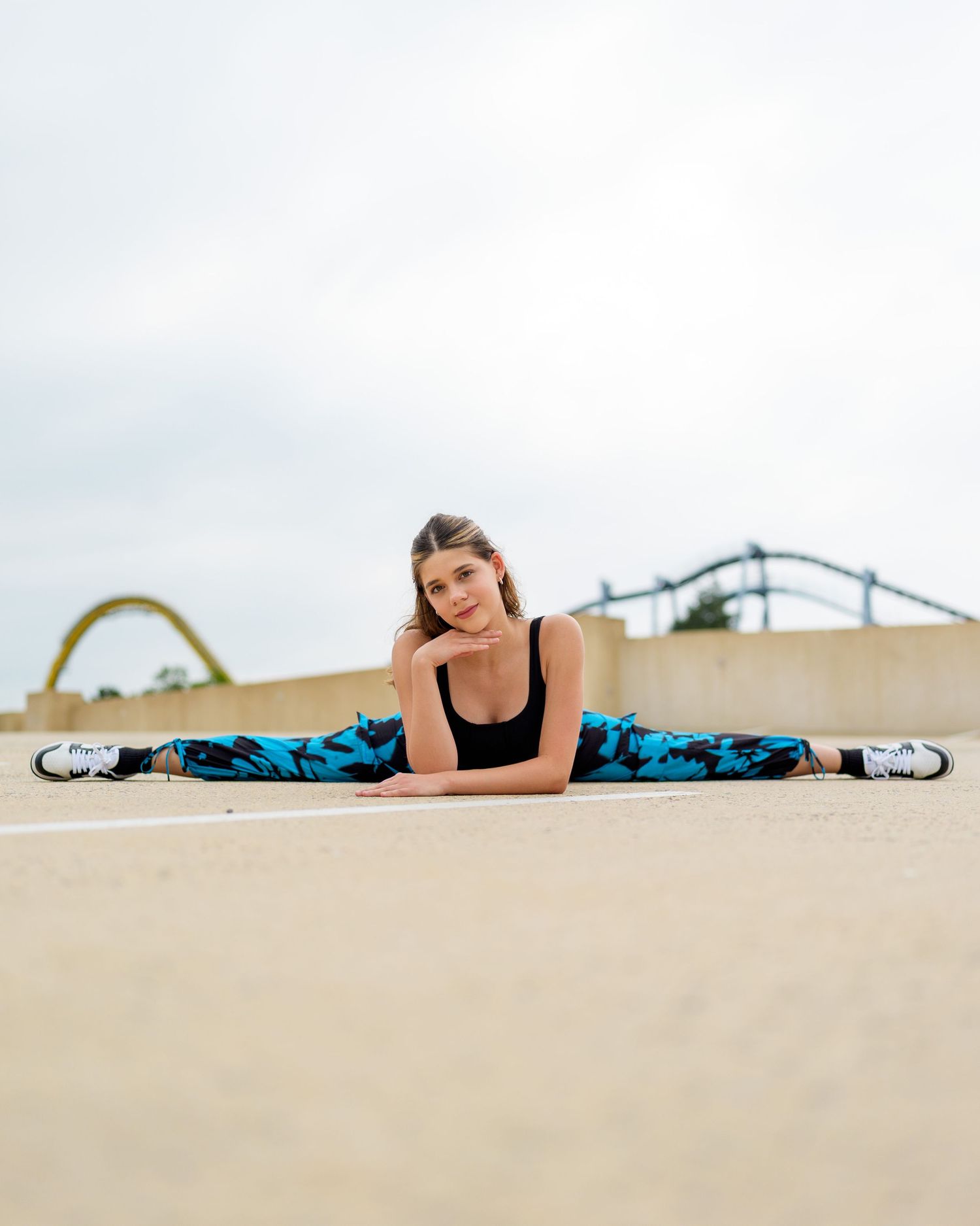 Person in blue patterned workout attire doing a side plank exercise on a sandy beach.