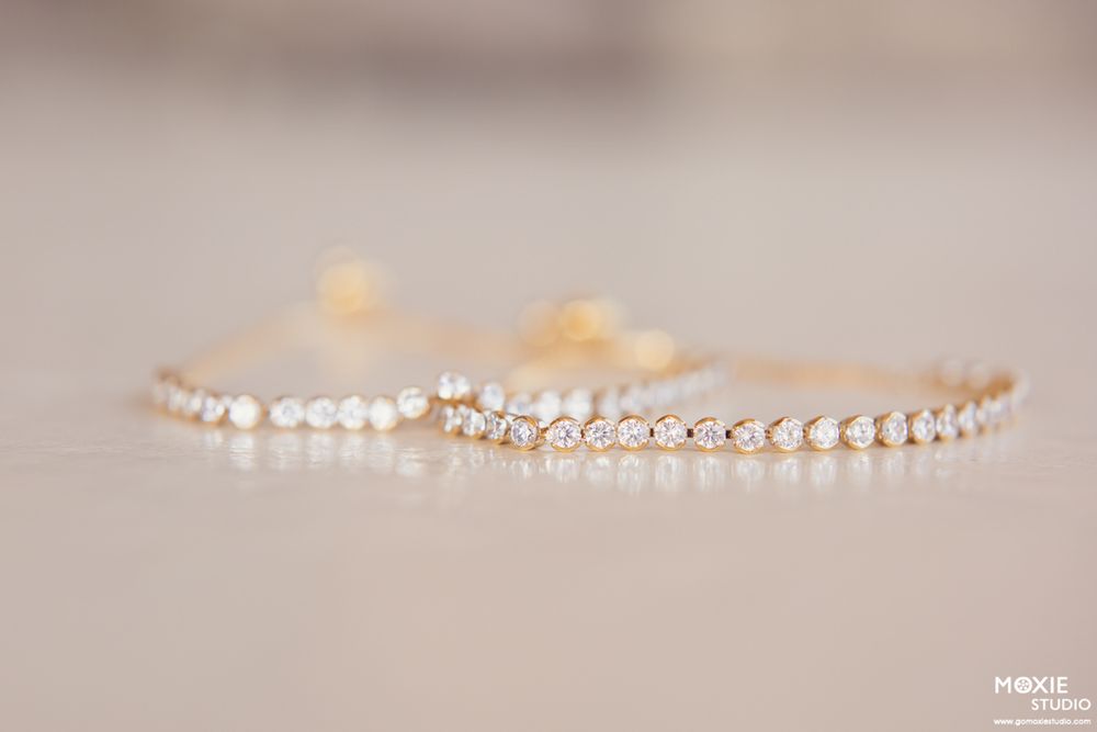 A delicate rose gold tennis bracelet with small round diamonds sparkles against a light neutral background.