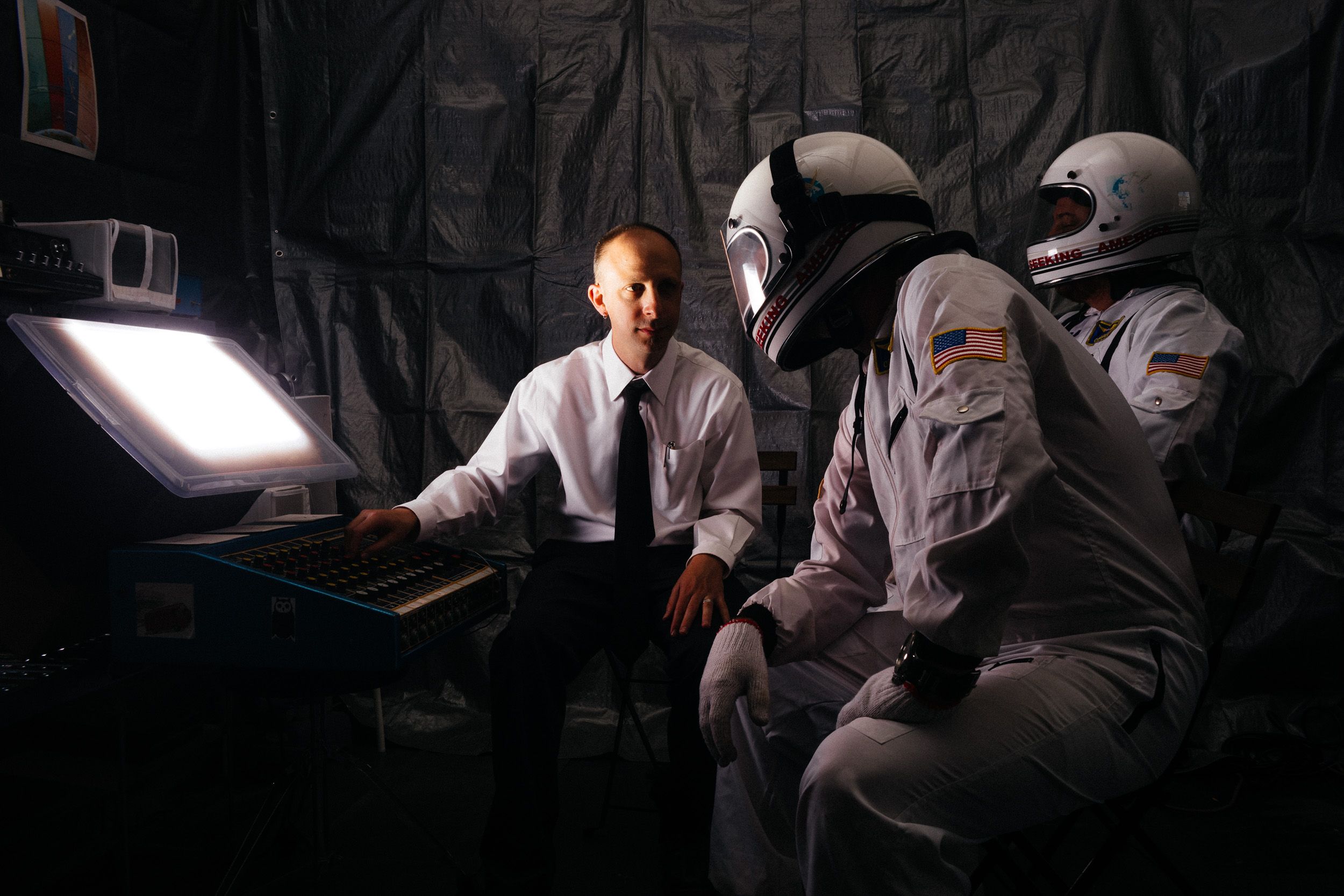 Dramatic black and white photo sequence showing a person in a white shirt sitting in dark lighting.