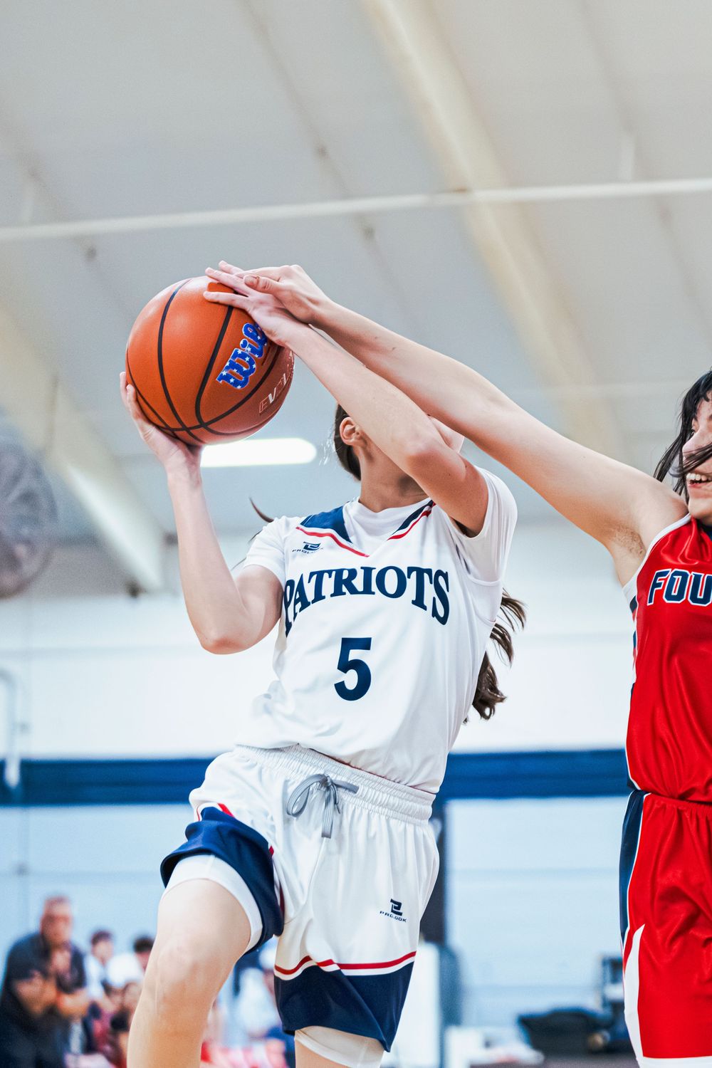 Girls Basketball player jumping up for a layup
