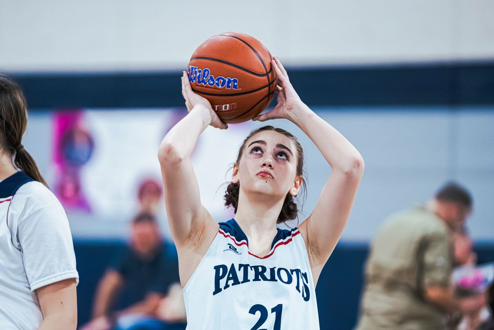 Girls Basketball player shooting the ball from mid court
