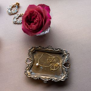 Vintage ornate silver tray with deep red rose and decorative details.
