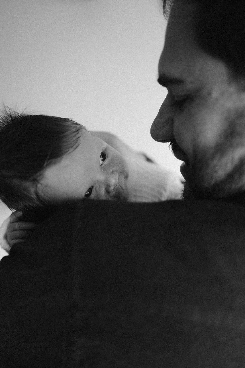 A tender black and white portrait of a parent and child sharing an intimate moment together.