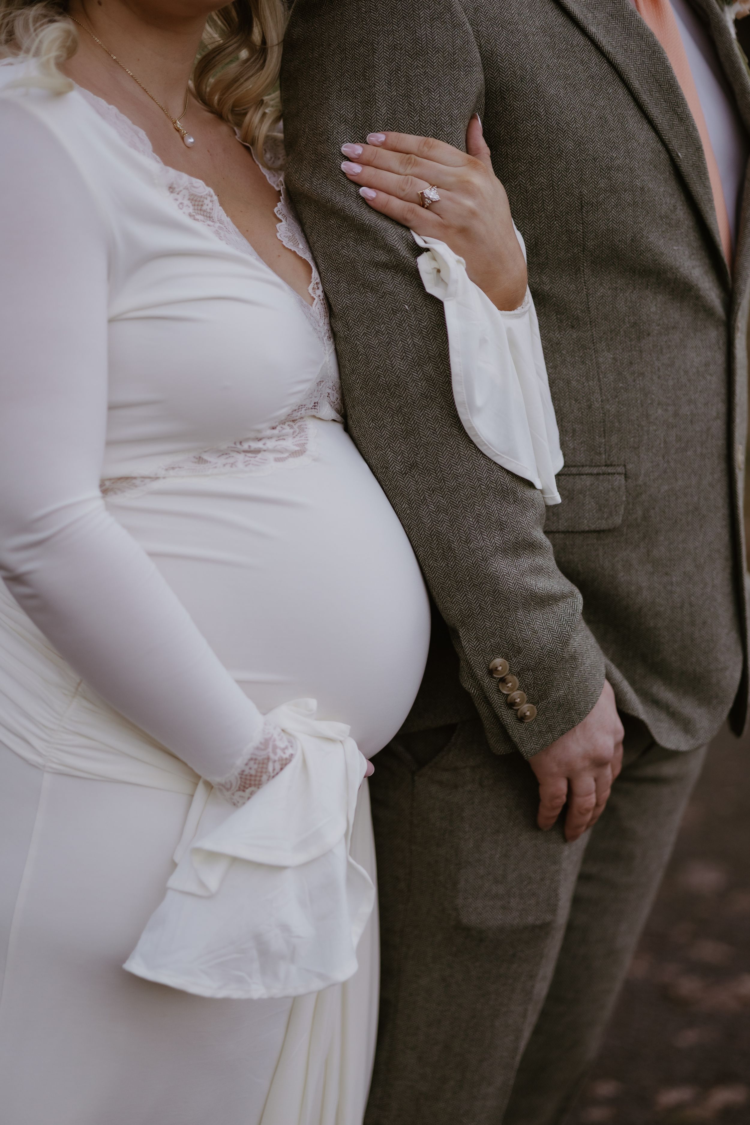 Close-up details of a modern white wedding dress with fitted silhouette.