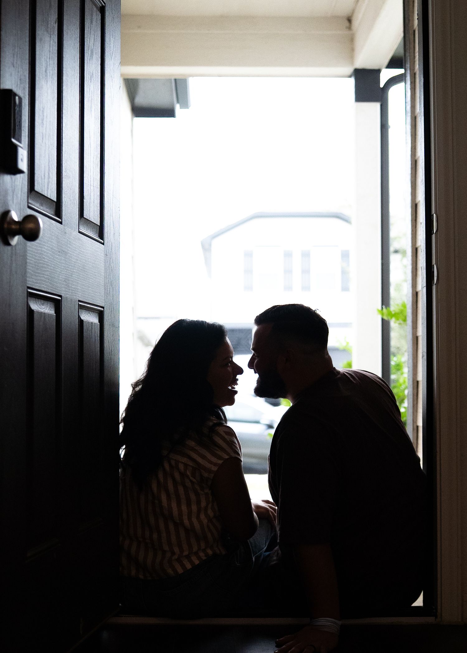 The Emerson Family of five posing in their empty new home, smiling and exploring their new space together
