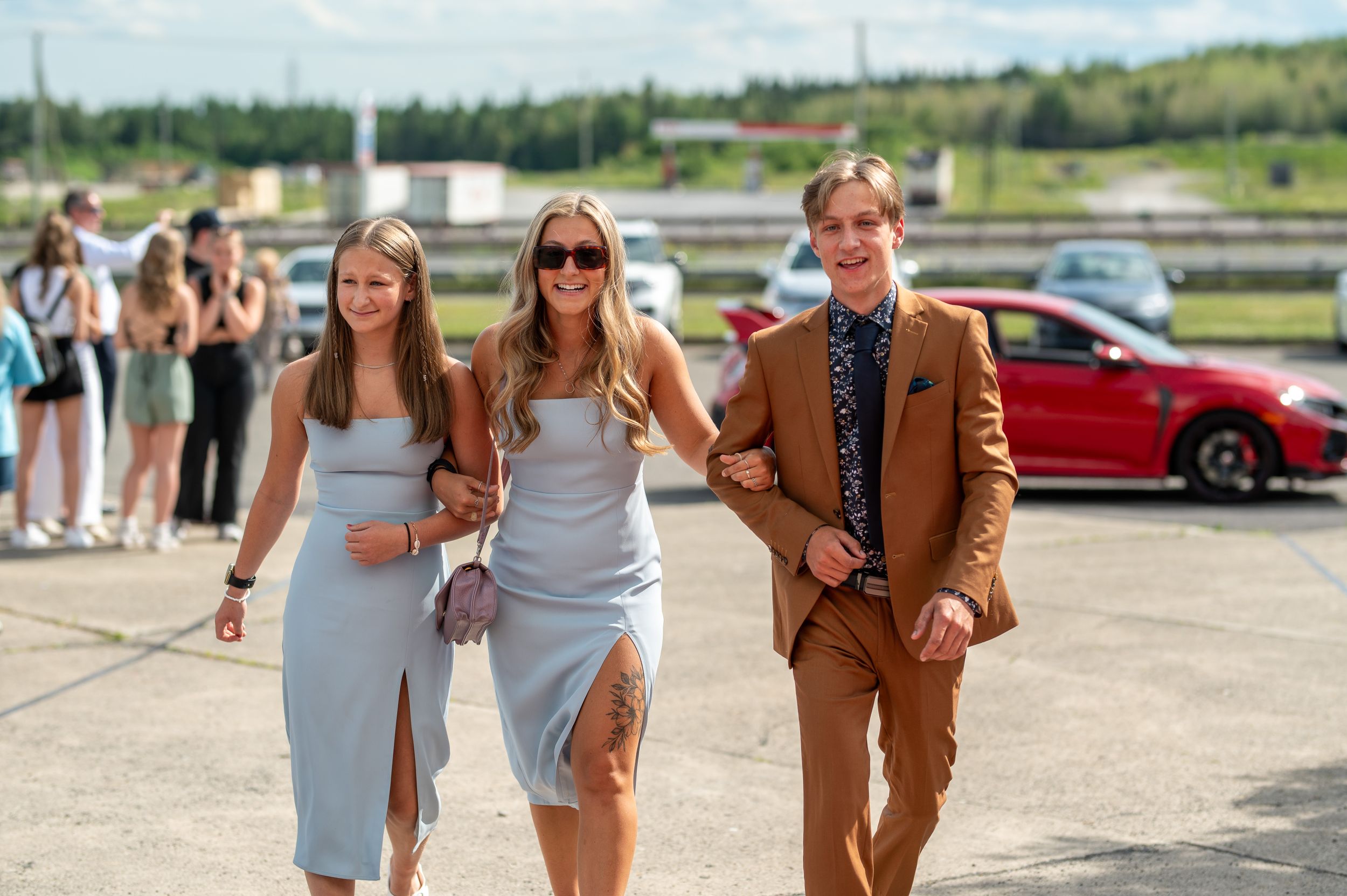 Group walking together at formal event, with crowd in background.