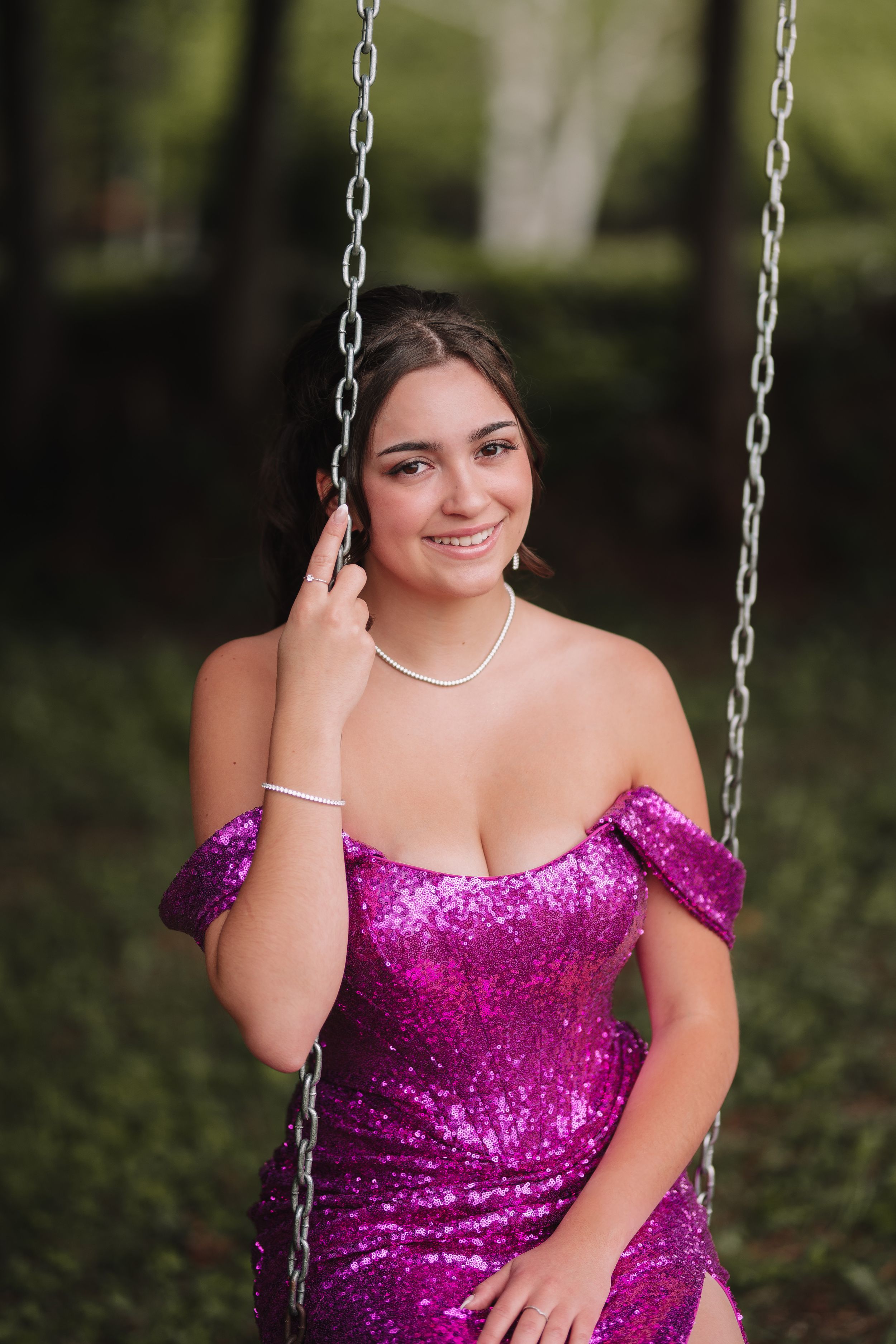 Portrait on swing featuring sparkly magenta off-shoulder formal dress.