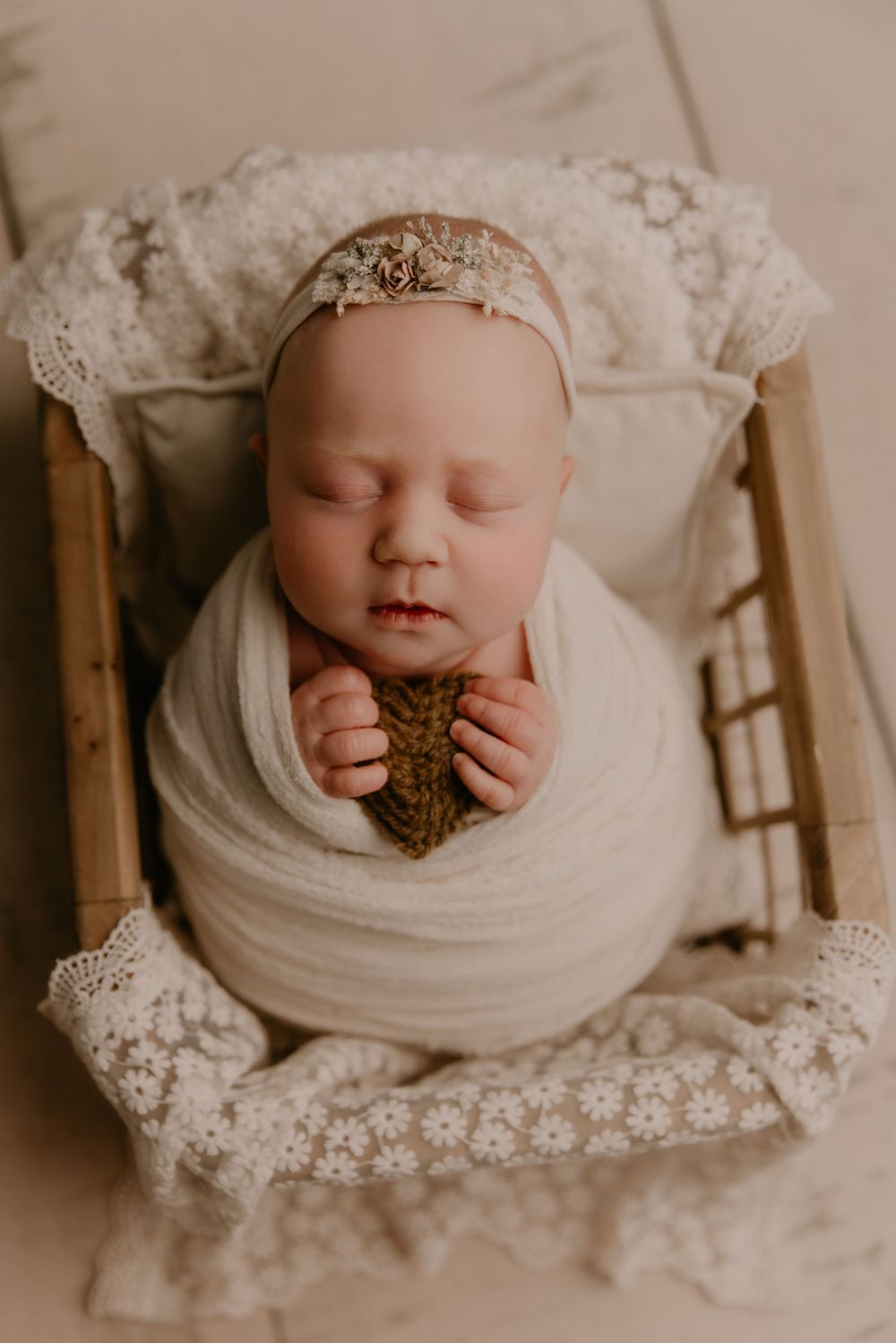A sepia-toned collage of newborn photography featuring delicate lace details and soft wrapping in vintage style.