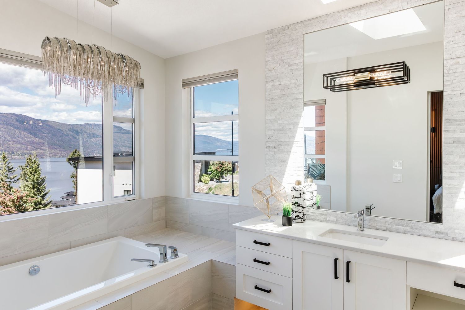 Bright white bathroom with modern fixtures, floating vanity, and large mirror in a Kelowna Airbnb
