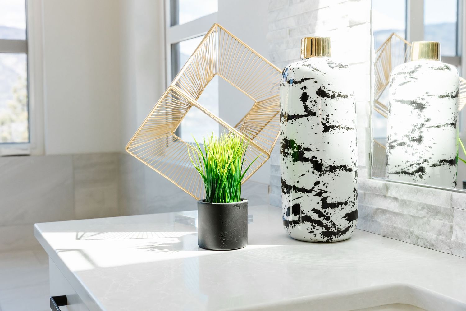 White bathroom counter featuring geometric gold decor pieces and marble accents in a Kelowna Airbnb