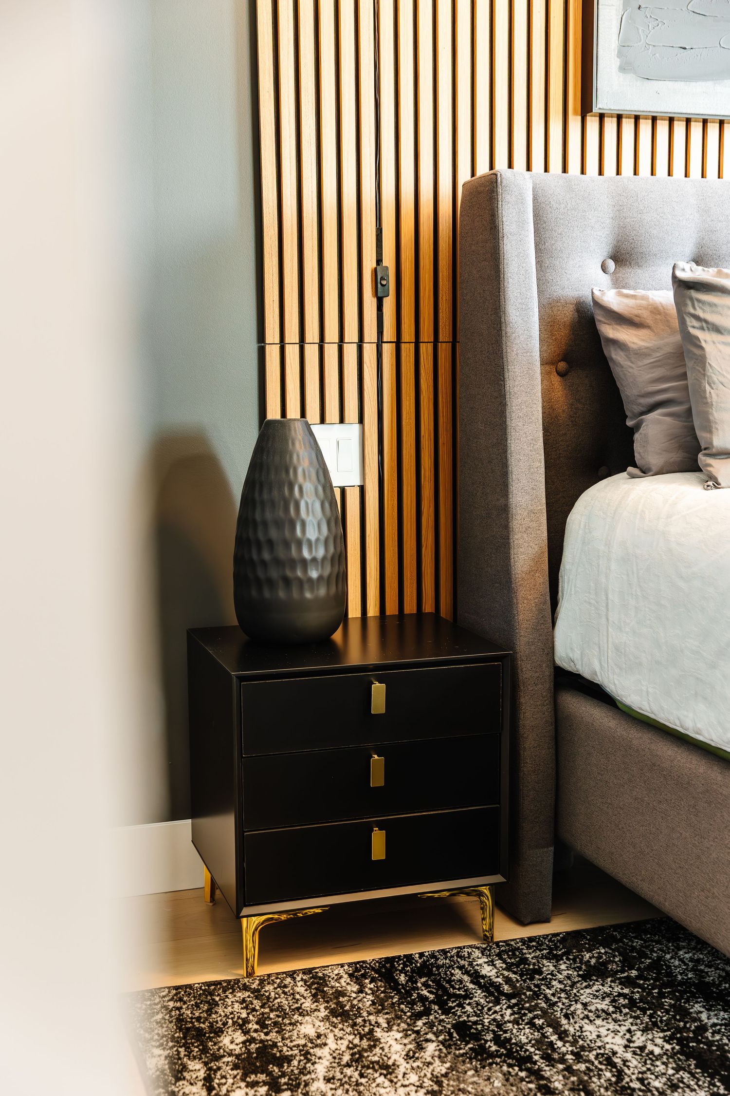 Elegant bedroom corner featuring vertical wood slats and contemporary decor in a west Kelowna Airbnb